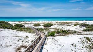 A wooden boardwalk leading to a beach with clear blue water and white sand. - Royal Blue | Gated Neighborhood, Dedicated Beach Access, Golf Cart + Bikes (SANTA ROSA BEACH)