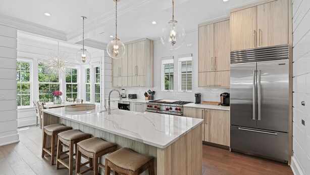 A modern kitchen with a large island, stainless steel appliances, and wooden cabinetry. - Royal Blue | Gated Neighborhood, Dedicated Beach Access, Golf Cart + Bikes (SANTA ROSA BEACH)