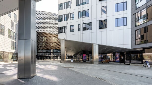 A modern building with a covered entrance, large windows, and a distinctive facade. - 2ndhomes Tampere Opaali Apartment (Tampere)