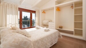 A bedroom with a bed, a wardrobe, and a balcony. - Alcudia's Best: Private Pool, BBQ, Inviting Garden (Alcúdia)