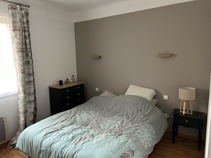 A bedroom with a bed, a nightstand, a dresser, and a window with curtains. - Apartment beziers (Béziers)