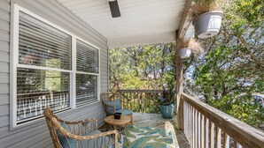 A covered porch with wicker furniture, a patterned rug, and potted plants. - Heaven At The Sound: Fully Remodeled | Dogs OK (Kill Devil Hills)