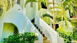 Un bâtiment blanc doté de plusieurs tours à coupole et d’un escalier menant à l’entrée.