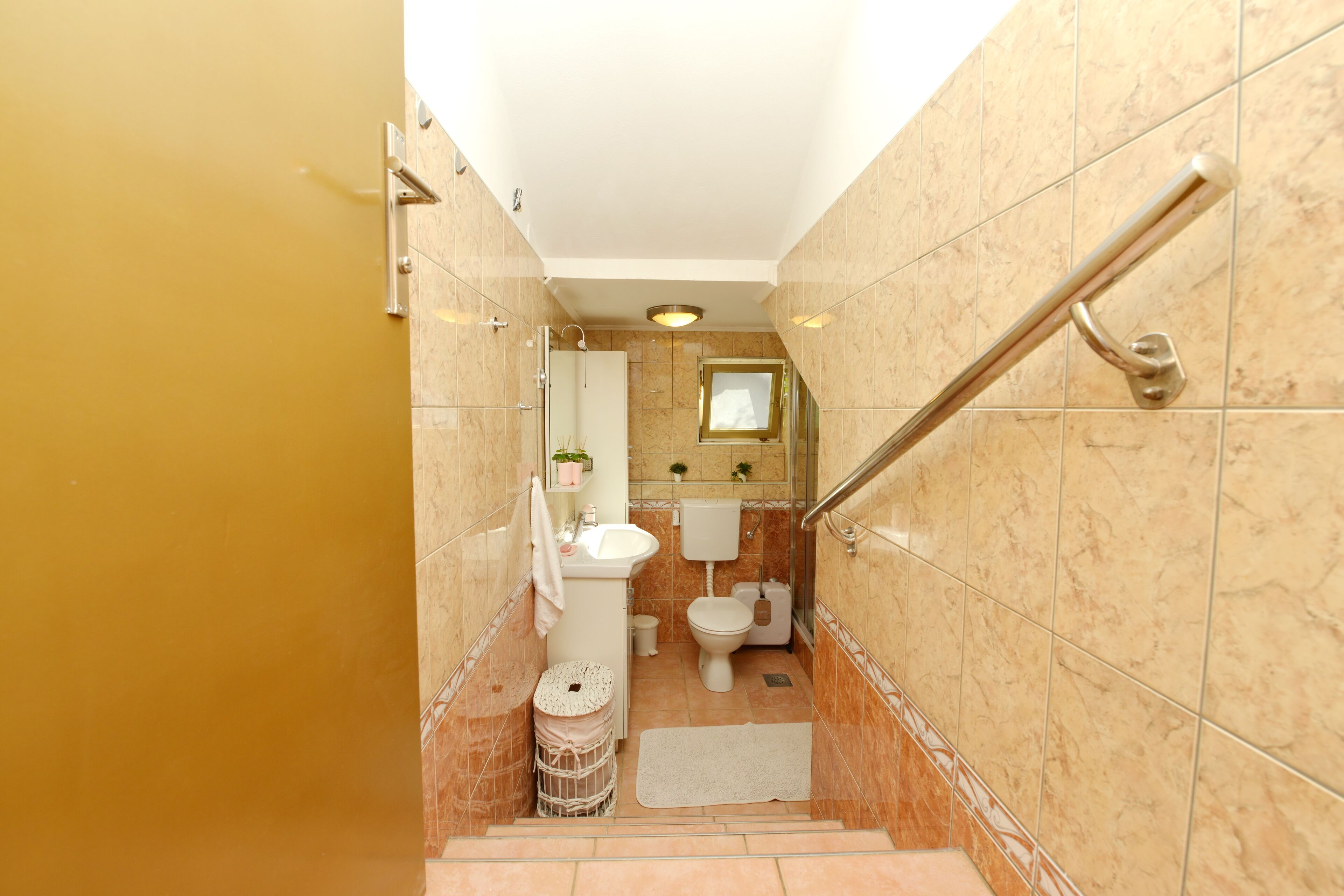 A bathroom with a toilet, sink, and shower area.
