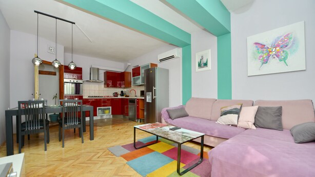 Un salon moderne avec un canapé, une table basse et un coin repas.