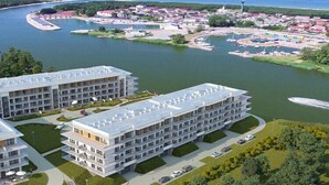 Un hôtel moderne à plusieurs étages, doté d’une cour intérieure et d’un port de plaisance avec des bateaux.