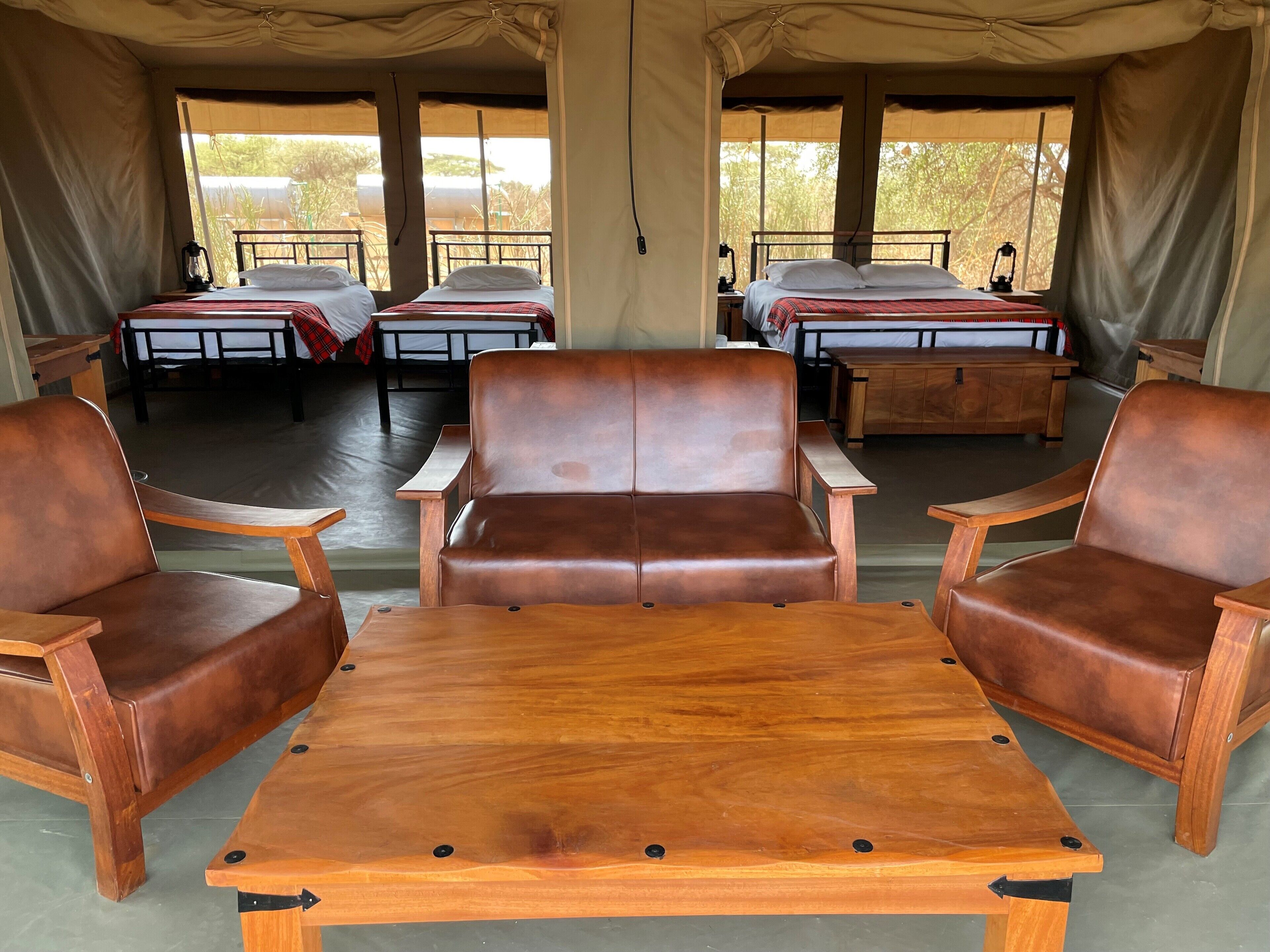 Eine Zelthütte mit zwei Betten, einem Sofa und einem Tisch.