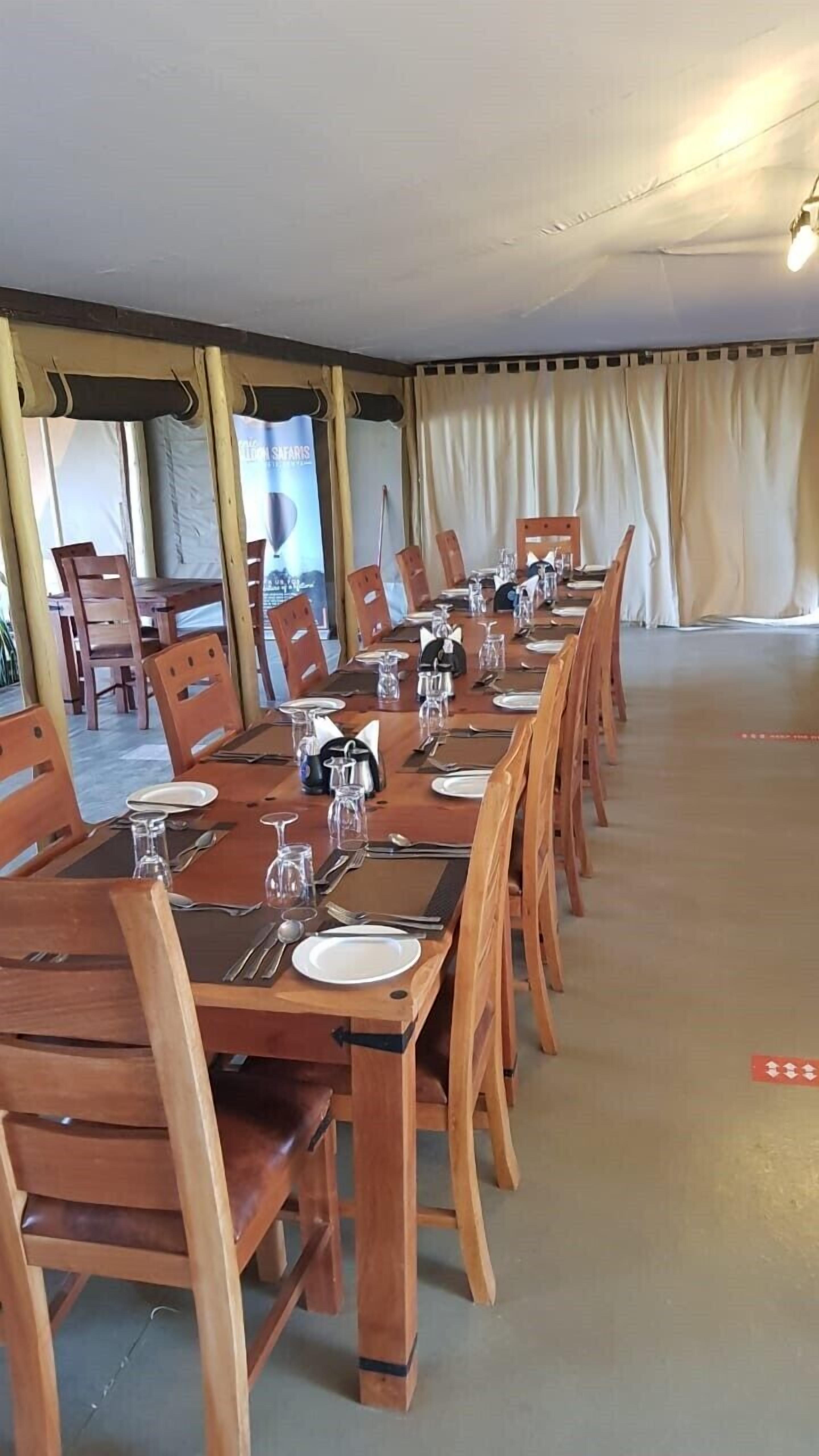 Una larga mesa de comedor dispuesta con sillas, un banderín y una cortina.