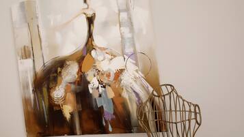 A painting of a bottle with abstract elements and a wireframe chair.