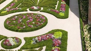 A formal garden with geometric patterns and flower beds, surrounded by historic buildings. - Le Porta 5 (Albi)