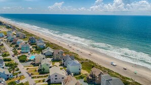 A coastal residential area with houses along the beach, a clear sky, and the ocean. - Sea La Vie | Oceanfront + Community Pool! (North Topsail Beach)