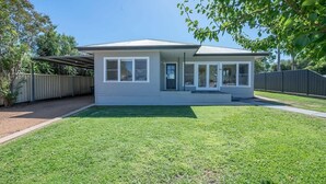 A single-story house with a covered porch, a front door, and a small front yard. - Cobbora Cottage -  Sleek & Stylish, Near Hospital (Dubbo)