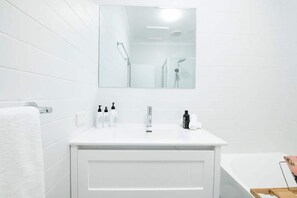 Bathtub, hair dryer, towels, shampoo