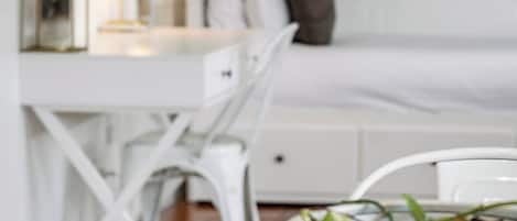 A white dining table with a wooden surface, a white chair, and a white decorative bowl with a textured pattern.