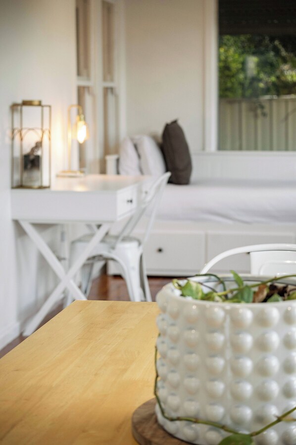 A white dining table with a wooden surface, a white chair, and a white decorative bowl with a textured pattern.