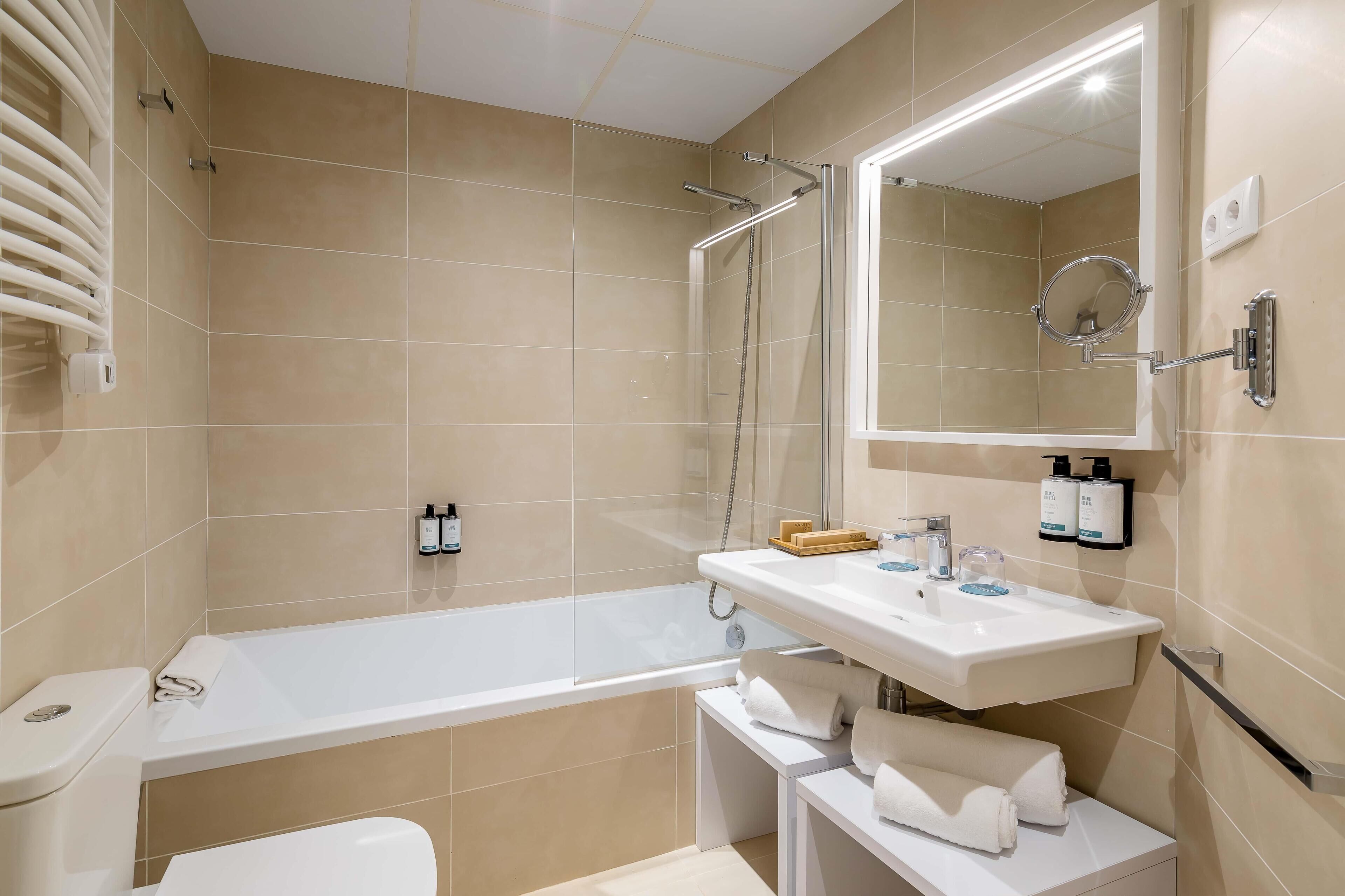 Un baño moderno con bañera, ducha y lavabo.