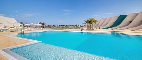 Een seizoensgebonden buitenzwembad, parasols voor strand/zwembad