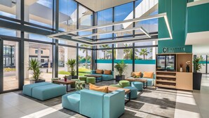 A modern indoor space with seating areas, large windows, and a visible outdoor view. - Occidental Mar Menor (Cartagena)