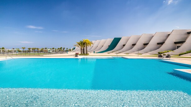 A large, clear blue pool with a modern architectural backdrop. - Occidental Mar Menor (Cartagena)