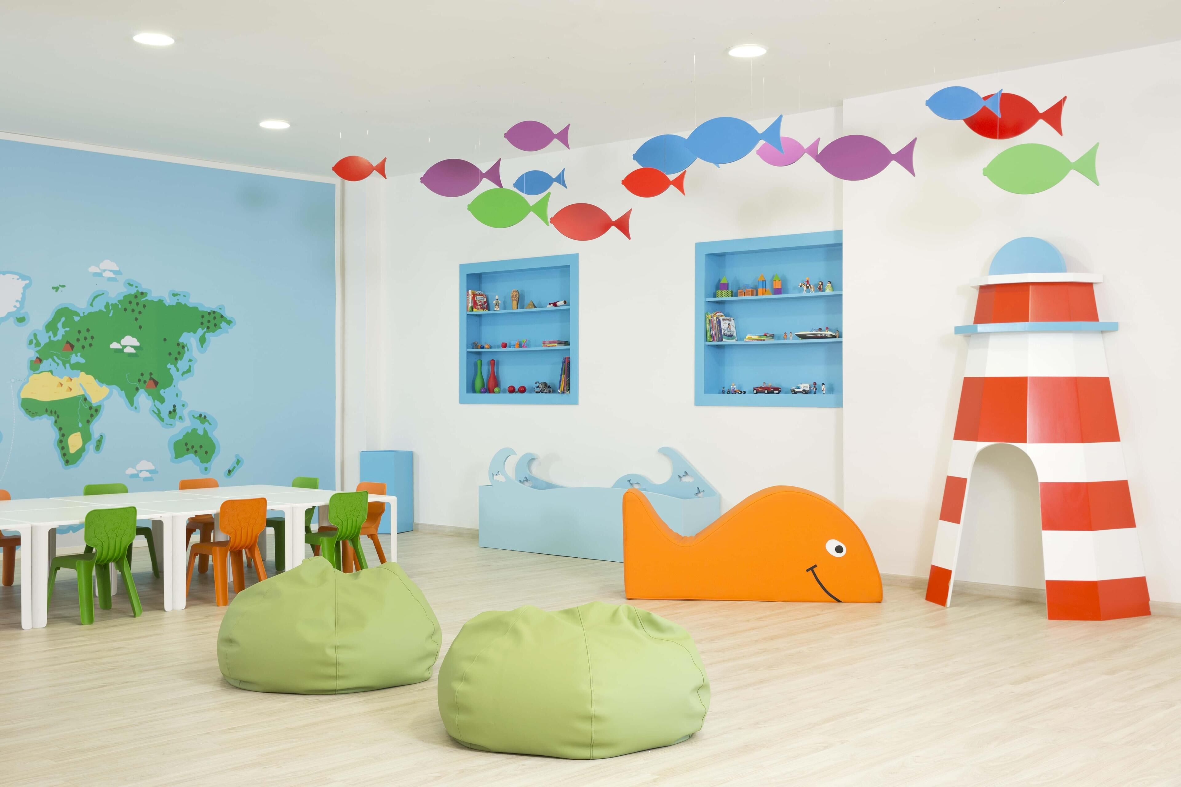 A children's playroom with a world map, colorful fish decorations, and playful furniture.