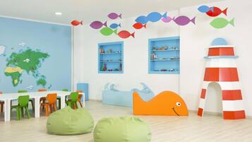 A children's playroom with a world map, colorful fish decorations, and playful furniture.