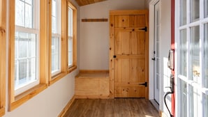 A hallway with wooden flooring, large windows, and a wooden door. - Minutes to Canandaigua Lake Boat Launch, Fireplace, Large Yard, Hiking (Naples)