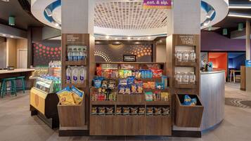 Un mercado Hilton Honors disponible las 24 horas con bocadillos, bebidas y zona de recepción.