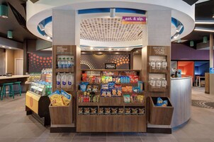 Un mercado Hilton Honors disponible las 24 horas con bocadillos, bebidas y zona de recepción.