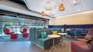 Ein stilvoller Lounge-Bereich mit Sitzgelegenheiten, Tischen und hängenden Leuchten.
