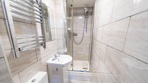 A small, modern bathroom with a shower, a toilet, and a sink. - Homely Studio Next to City Centre (Birmingham)