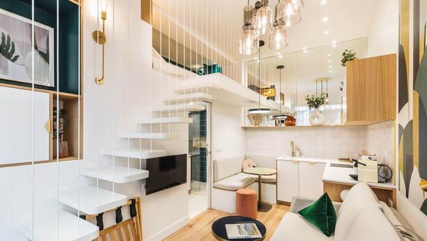 A modern interior with a staircase, a dining area, and a living room with a sofa and a coffee table. - ParisConciergerie - Design studio in Paris (Paris)