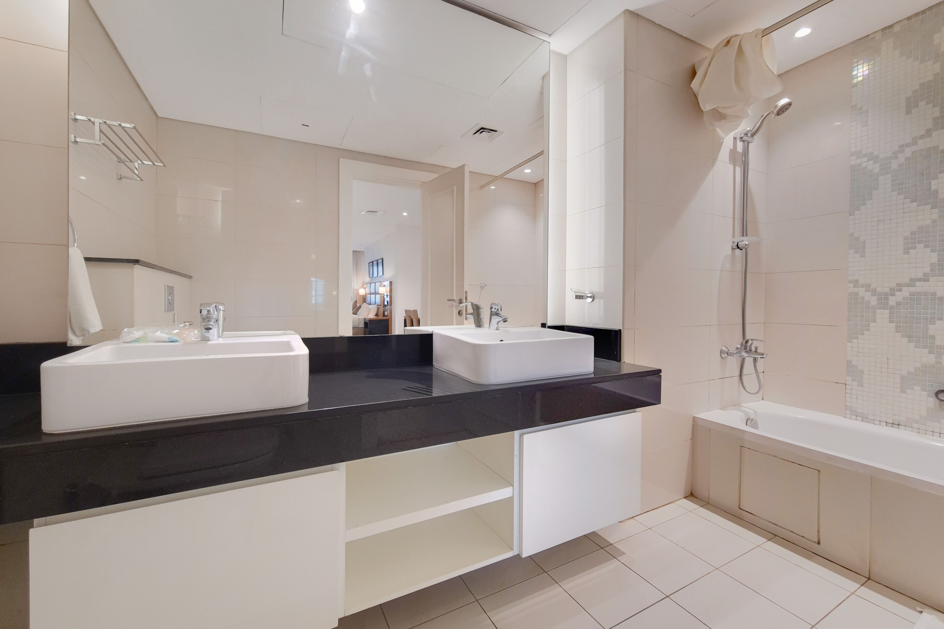 A modern bathroom with two sinks, a bathtub, and a shower.