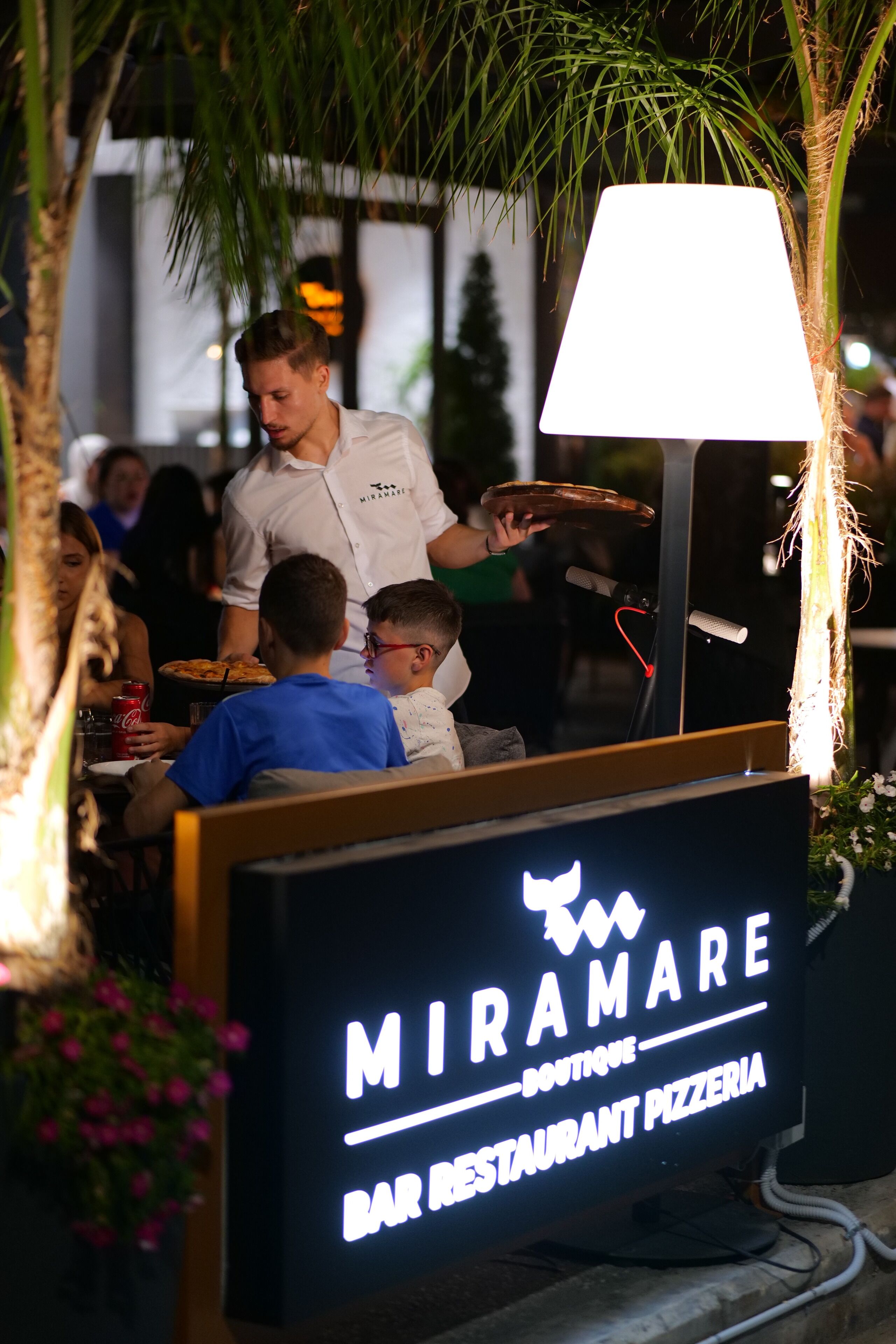 A restaurant sign with the name 'MIRAMARE' and 'BAR RESTAURANT PIZZERIA' visible.