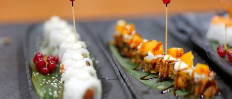 A close-up of a sushi platter with various toppings and garnishes.
