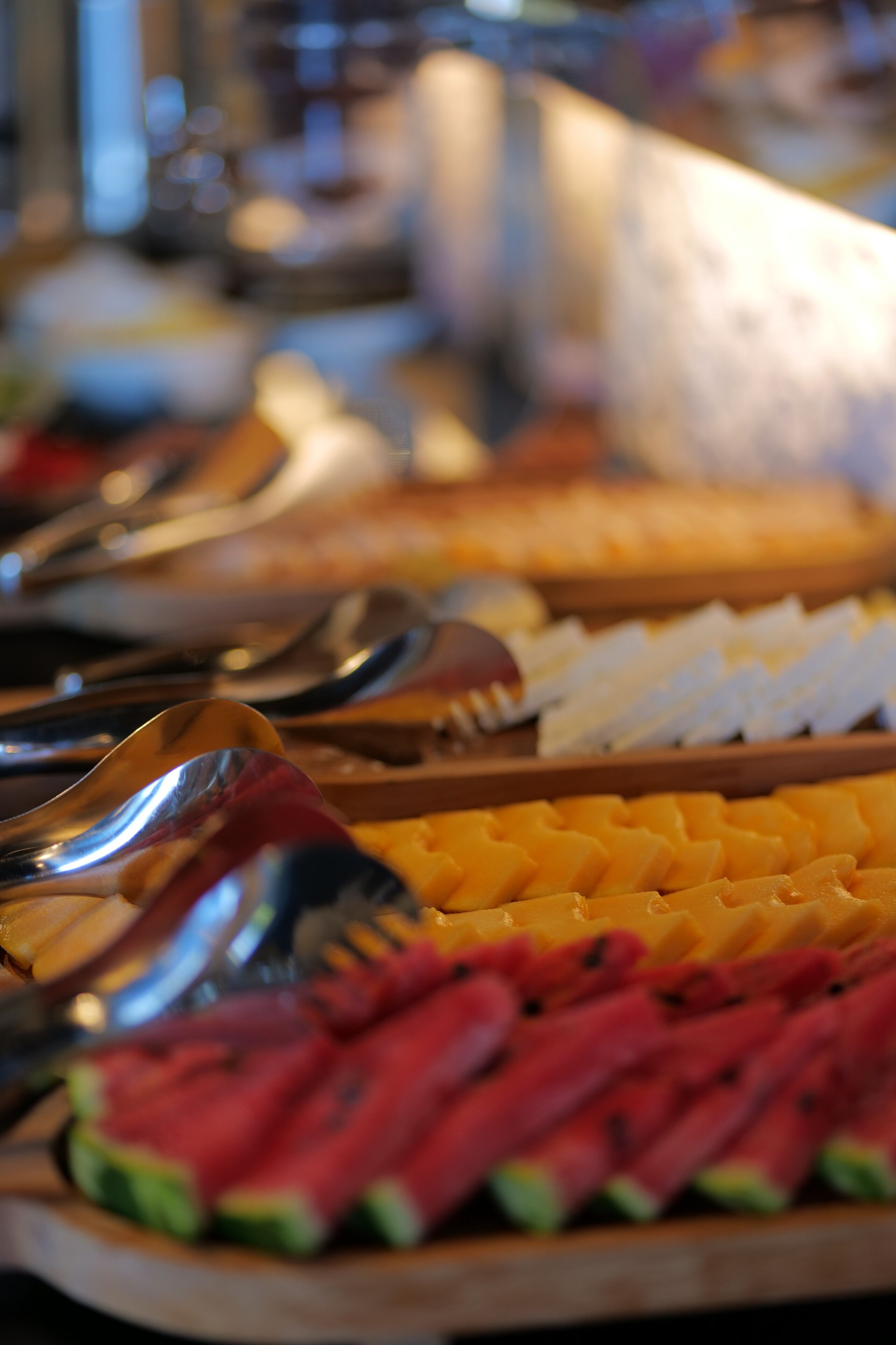 Buffet com diversas opções de alimentos, incluindo frutas e queijos.