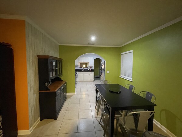 A kitchen with white cabinets, a dining table, and chairs.