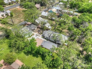 An aerial view of a residential area with houses, trees, and a clear sky.