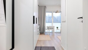 A hallway leading to a dining area with a view of the outdoors. - Forenom Serviced Apts Espoo Saunalahti (Espoo)
