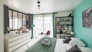 Un dormitorio moderno con una cama, un aparador, una estantería y una ventana con cortinas.