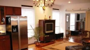 A spacious living area with a large wooden dining table, a sofa, and a television. - 1831 House in Historic Old Towne Petersburg, VA (Petersburg)