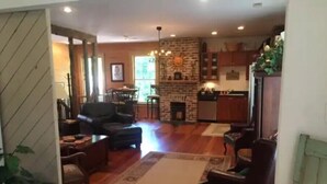 A spacious living area with a fireplace, wooden flooring, and a dining area with a table and chairs. - 1831 House in Historic Old Towne Petersburg, VA (Petersburg)