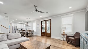 A spacious living room with a wooden coffee table, a sofa, and a dining area with chairs.