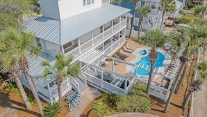 A multi-story building with a pool and outdoor seating.