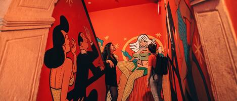A staircase with a mural of stylized figures and a large circular design.