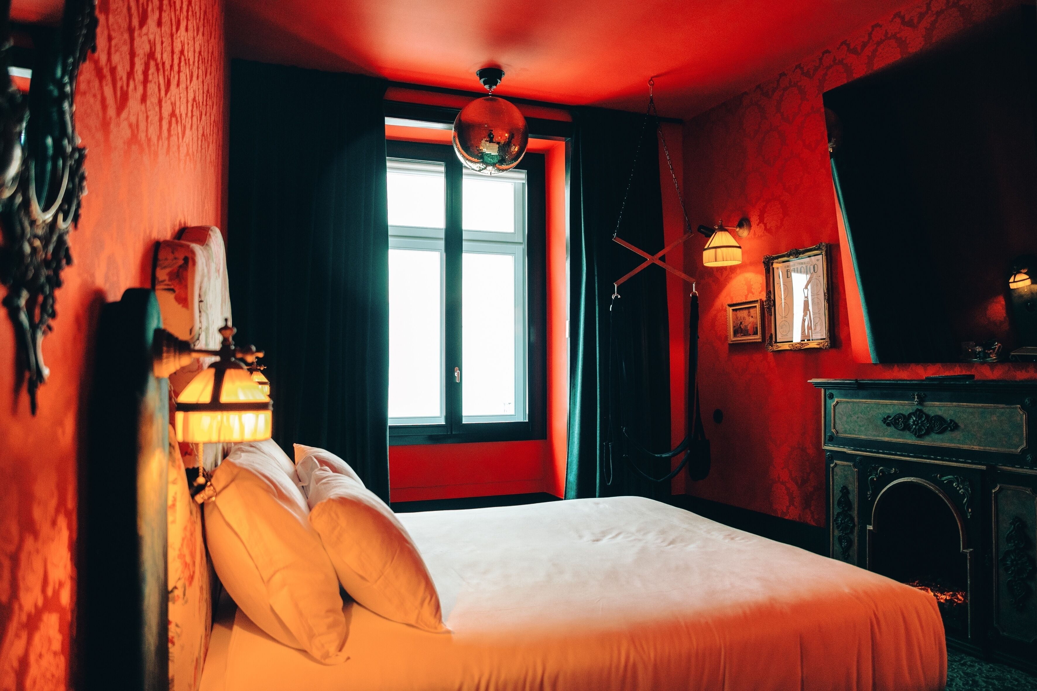 A room with a bed, a window, a lamp, and a dresser.