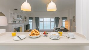 Une cuisine équipée pour préparer le petit-déjeuner, une cheminée et une vue sur la mer.