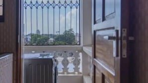 Un couloir étroit menant à un balcon agrémenté d’une grille en métal et d’un petit évier.