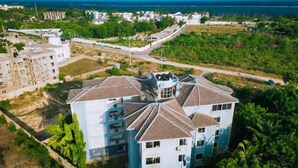 A multi-story building with a central courtyard, surrounded by greenery and a coastal view. - Hibiscus Homes-Shanzu(3bedroom) (Mombasa)