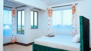 A bedroom with a bed, curtains, and a window. - Hibiscus Homes-Shanzu(3bedroom) (Mombasa)
