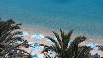 En la playa, sillas reclinables de playa, sombrillas, bar en la playa